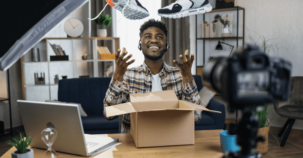 Afro man unboxing sneakers for creating video content