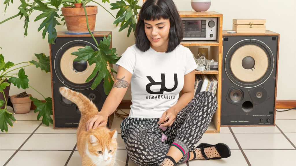 RemarkableU merch top worn by a woman playing with her cat