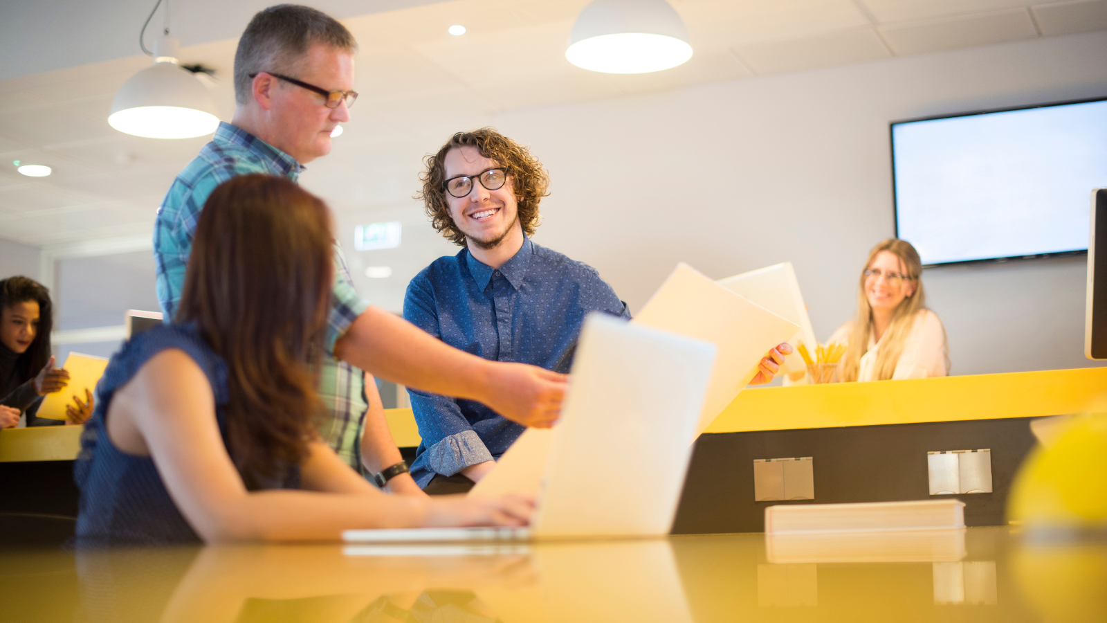 a group of people standing in front of a desk