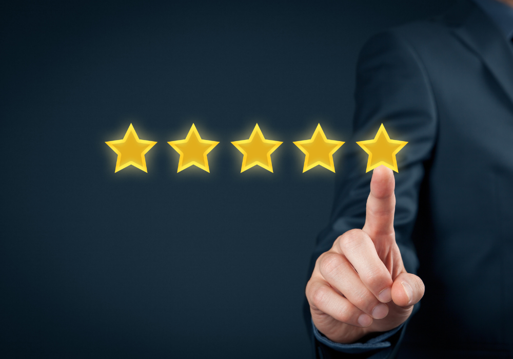 a person in a suit is pointing at five stars on a dark background