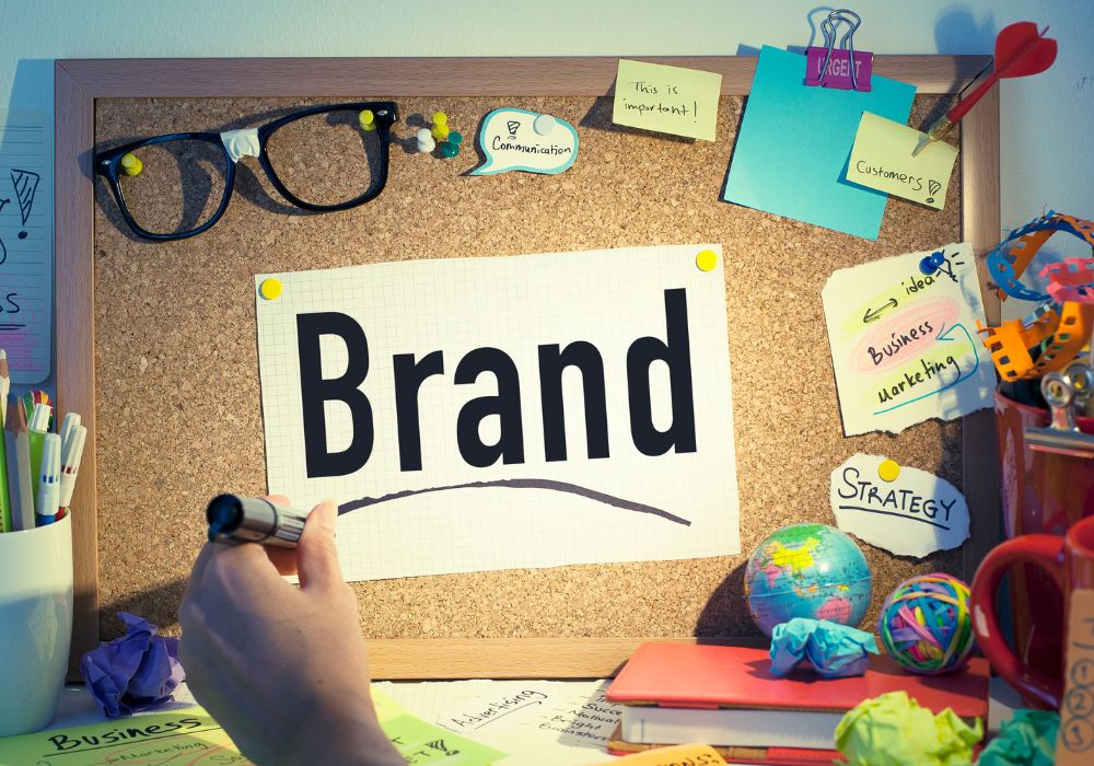 magnetic message formula: A corkboard with the word "Brand" prominently displayed, surrounded by sticky notes with words like "Communication", "This is important!", "Customers", "Idea", "Business Marketing", and "Strategy".